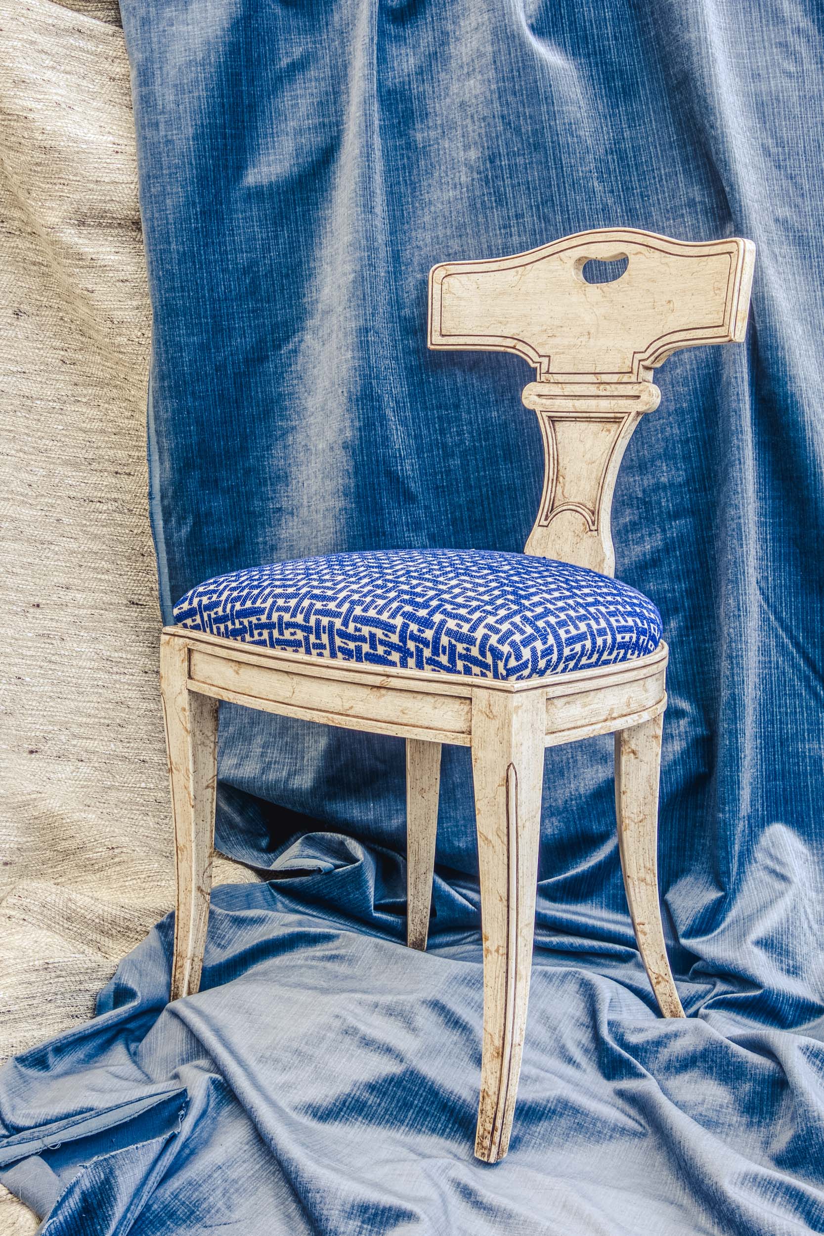 Still life of a chair on a blue and white backdrop in the Bussandri Villa
